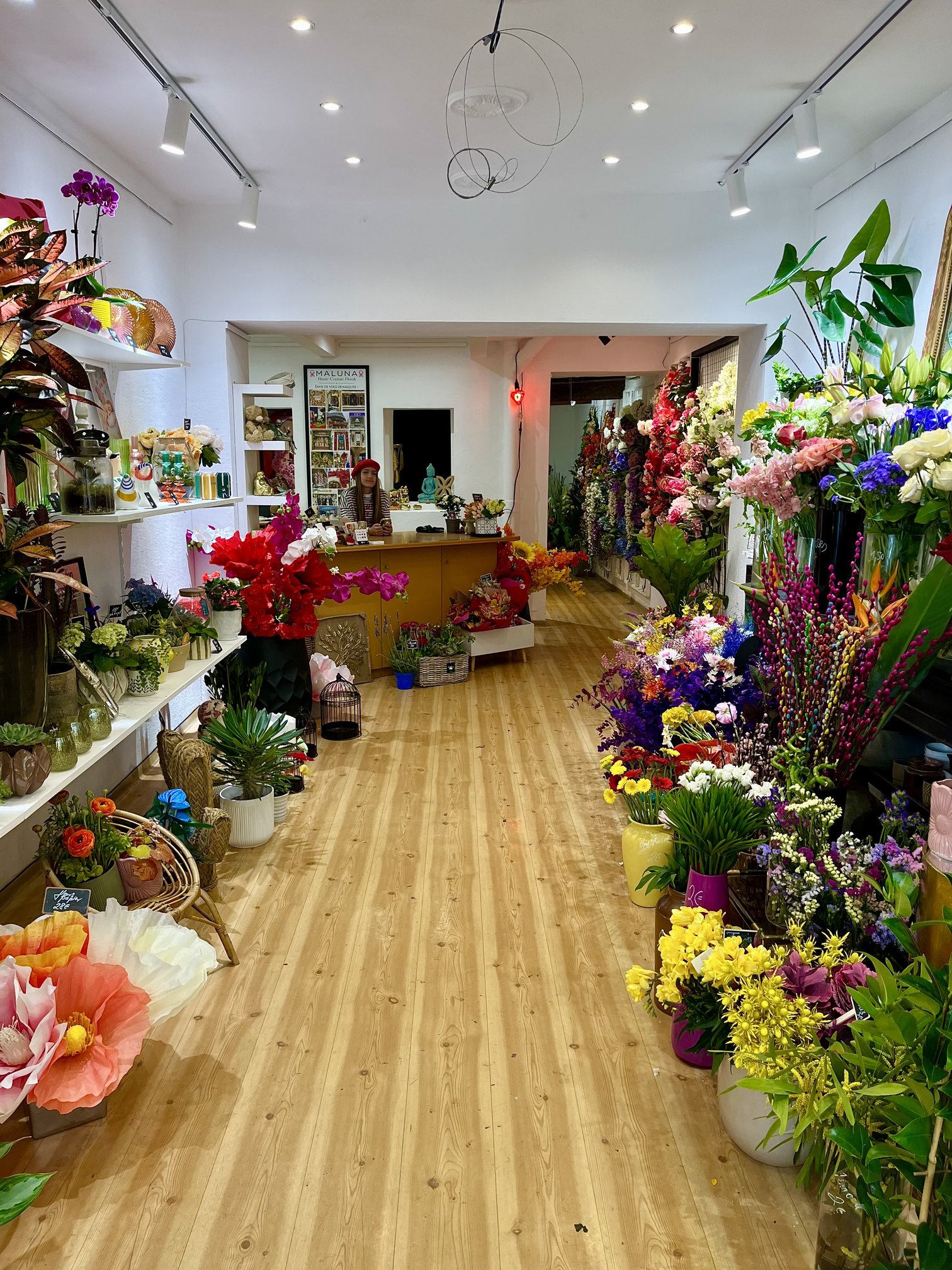 Intérieur de la boutique Maluna à Toulon, allée bordée de fleurs artificielles colorées