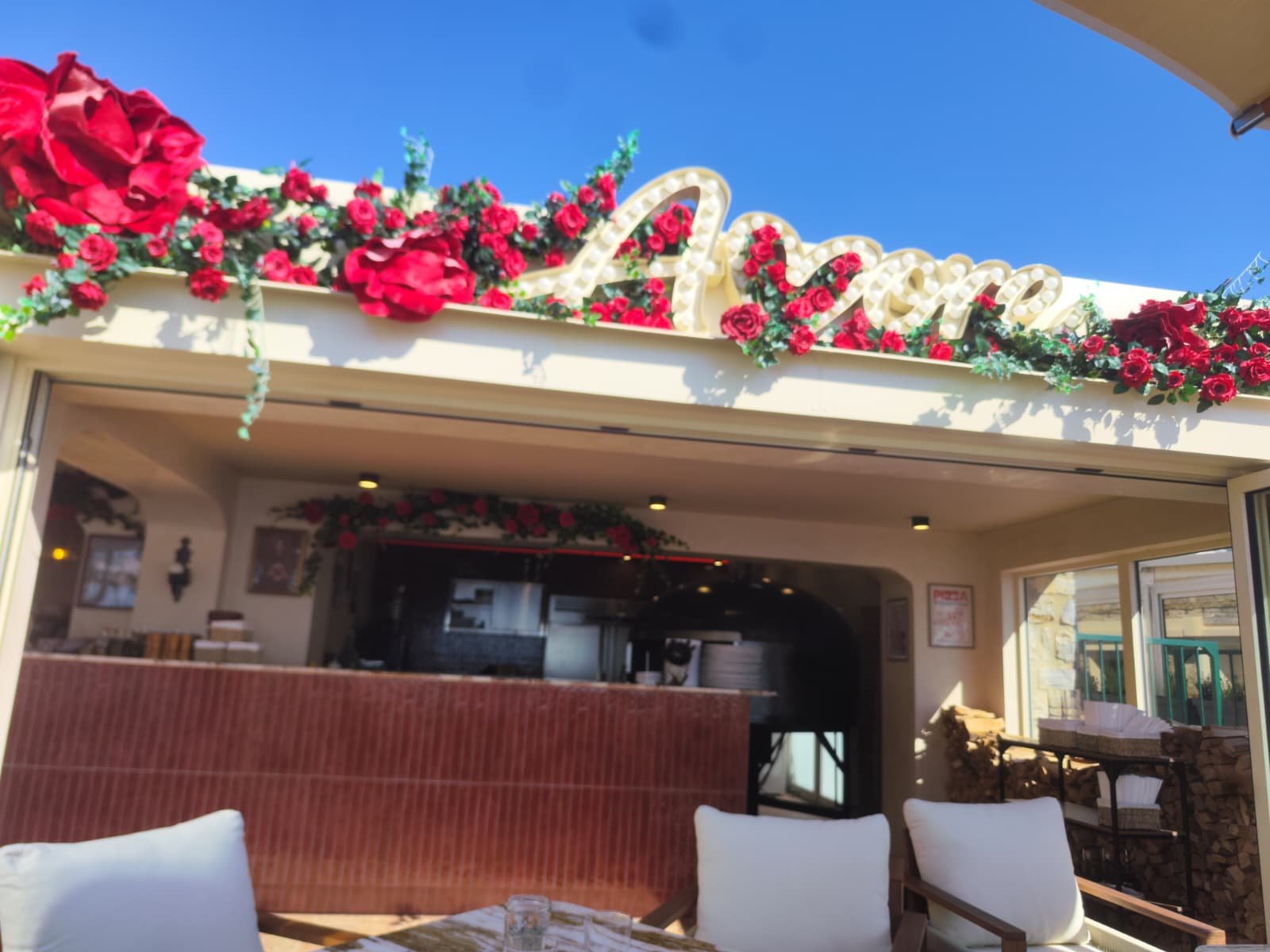Enseigne du restaurant Amore ornée de roses rouges artificielles à Toulon