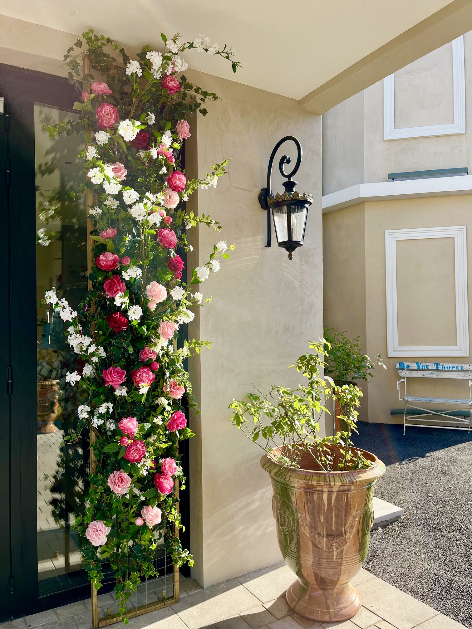 Treillage fleuri de roses et pivoines artificielles à l'entrée de l'hôtel Château Rose