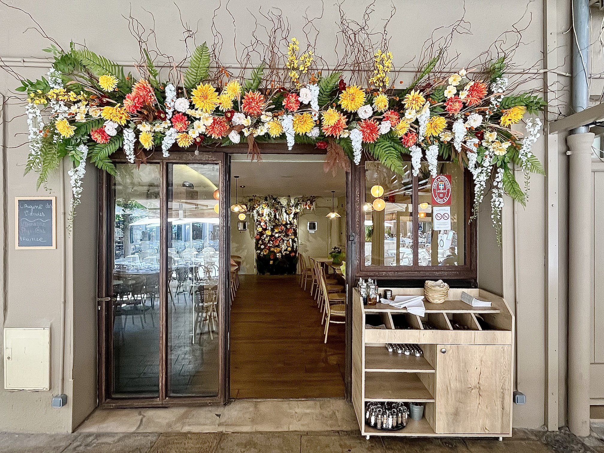 Enseigne fleurie du restaurant Le Floréal à Toulon avec dahlias artificiels jaunes et oranges