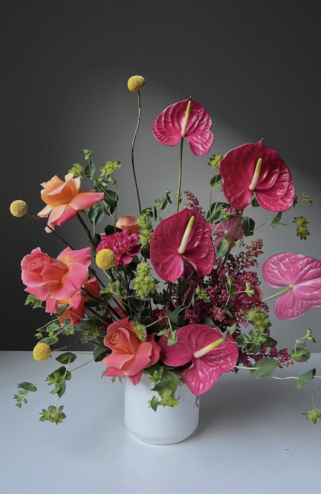 Composition artificielle en anthuriums fuchsia et roses pêche, disponible en location chez Maluna