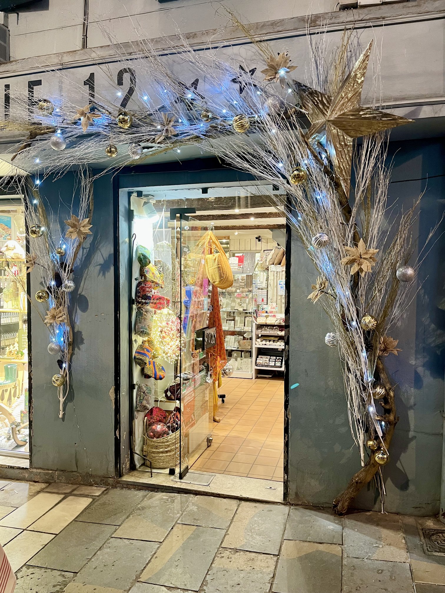 Arche de Noël argentée et dorée avec étoile scintillante à l'entrée de la Boutique 12 à Toulon