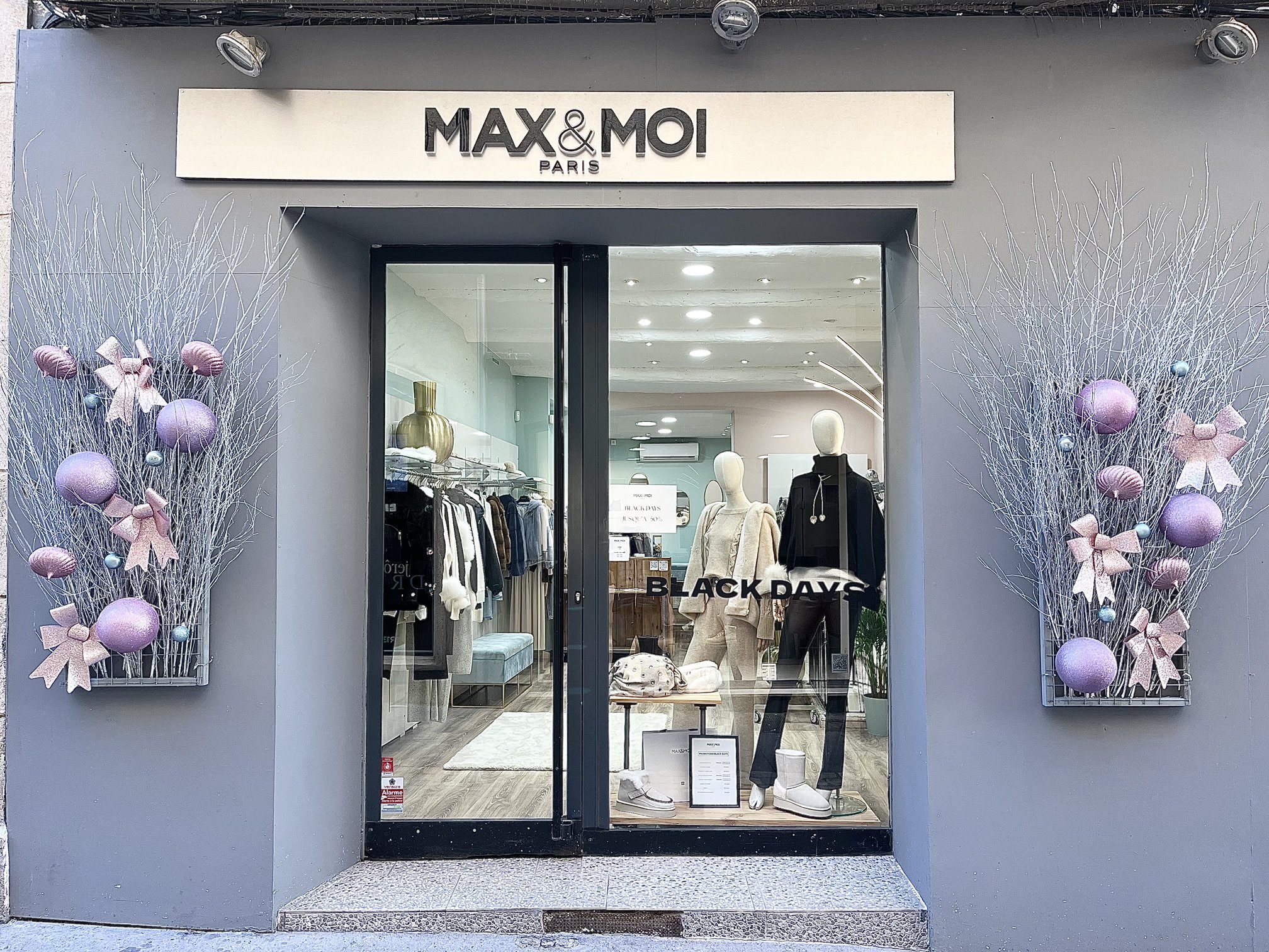Décoration de Noël en boules mauves et brindilles givrées à l'entrée de la boutique Max & Moi Paris à Toulon