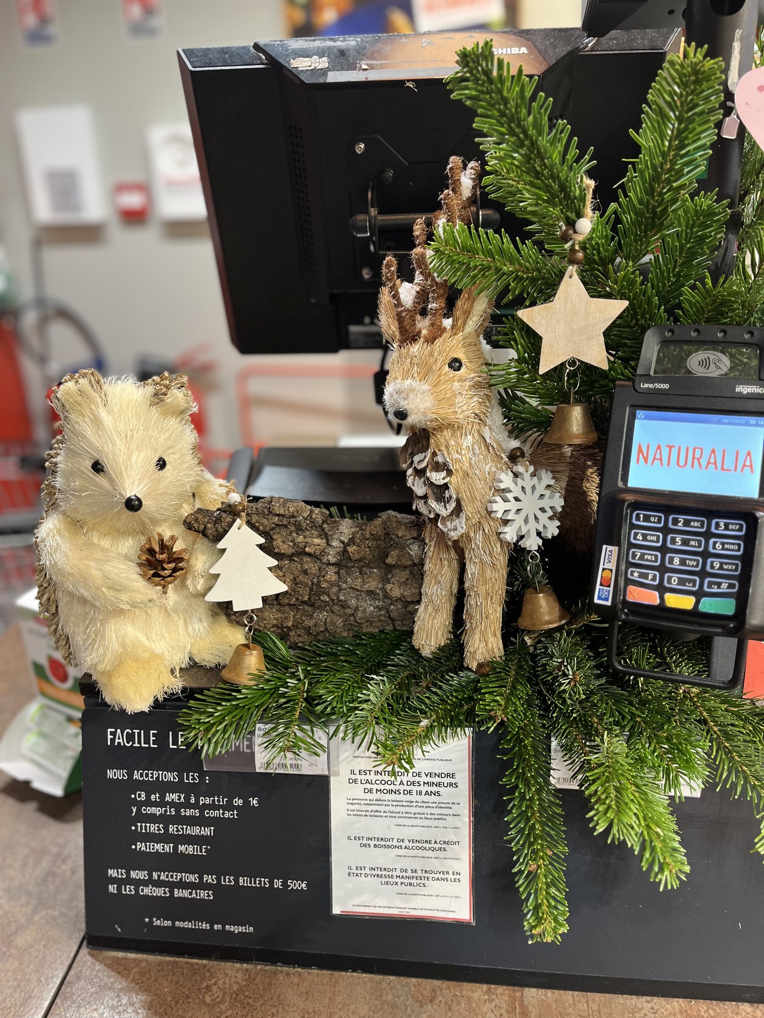 Décoration de Noël avec figurines animalières en raphia à la caisse du magasin Naturalia