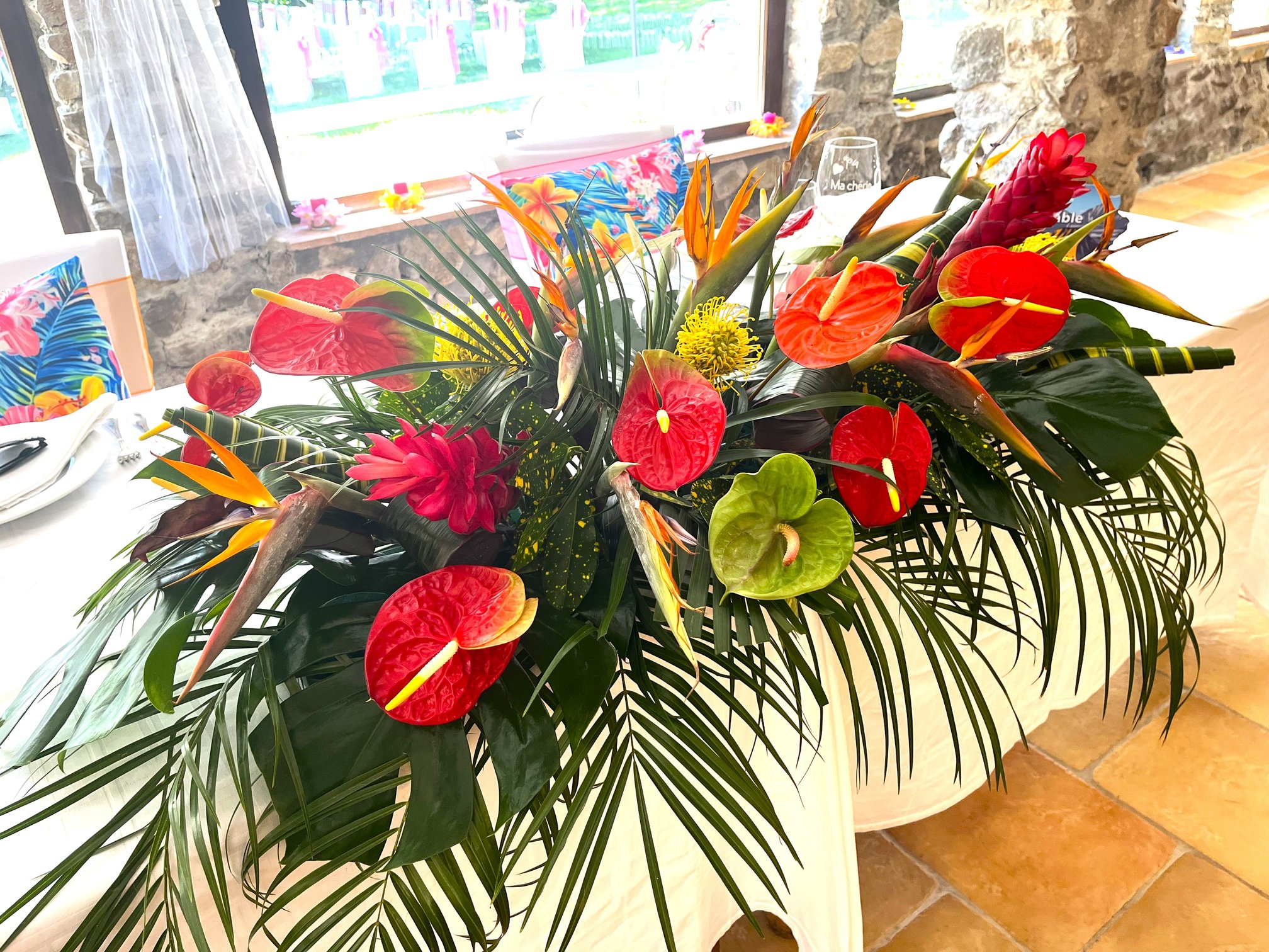 Table d'honneur exotique en anthuriums et oiseaux de paradis pour un mariage tropical