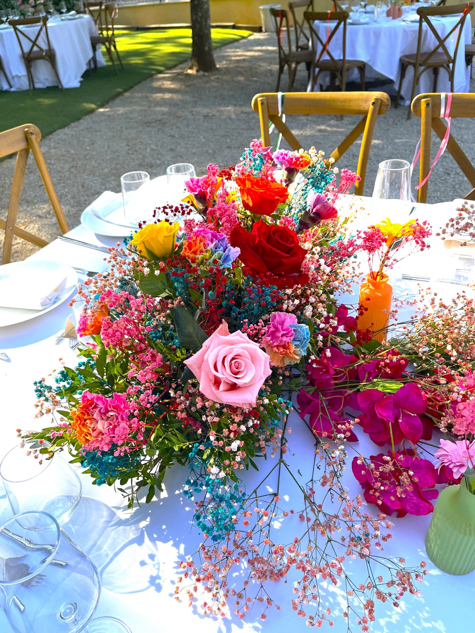Centre de table coloré en roses et fleurs multicolores pour un mariage